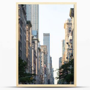 View down Fifth Avenue in Manhattan, New York City with historic buildings lining both sides of the street in NYC