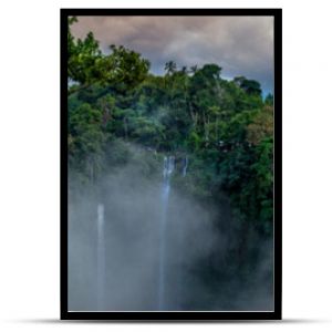 Antena nad wodospadem Sekumpul otoczonym gęstym lasem deszczowym i górami spowitymi mgłą o wschodzie słońca Bali Indonezja panorama