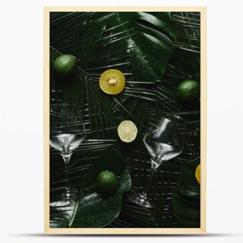 top view of two empty glasses, fresh fruits and green tropical leaves 