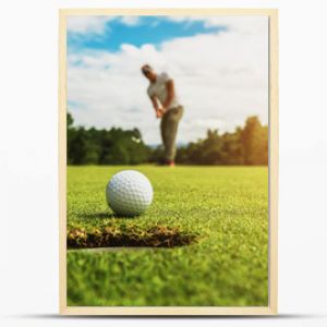 golfista wkładający piłeczkę golfową do dołka