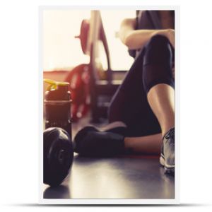 Kobieta ćwiczy ćwiczenia na siłowni, łamanie fitness, relaksuje się, trzymając jabłko po treningu sportowym z hantlami i koktajlem proteinowym bo