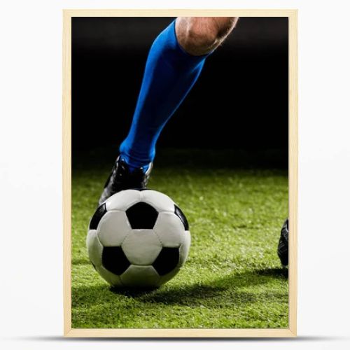 cropped view of sportsman playing with ball on green grass isolated on black