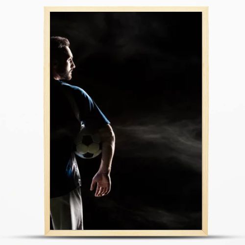 silhouette of football player holding ball on black with smoke  