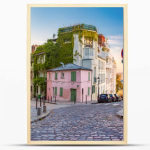 Przytulna stara ulica z różowym domem w słonecznej dzielnicy Montmartre o wschodzie słońca w Paryżu we Francji