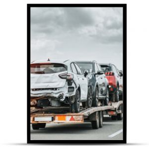 Awaryjna pomoc drogowa na autostradzie, widok z boku lawety z uszkodzonymi pojazdami po wypadku drogowym