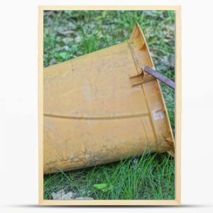 one large brown old plastic bucket dry closet stands in the green grass on the street