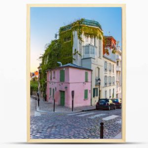 Cozy old street with pink house at the sunny sunrise, quarter Montmartre in Paris, France