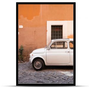 Vintage car parked in a cozy street in Trastevere, Rome, Italy, Europe.