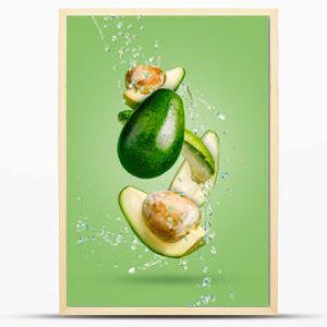 Fresh avocado cut into slices with water drops splash flying in the air and levitate on a mint green background. Healthy diet ingredient recipe. Trendy motion food composition. Creative fruit concept.