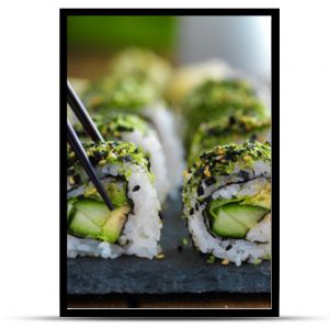 healthy kale and avocado sushi roll with chopsticks