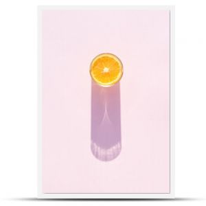 Glass of drink with orange on a pink background. Aesthetic long shadow glass summer concept.