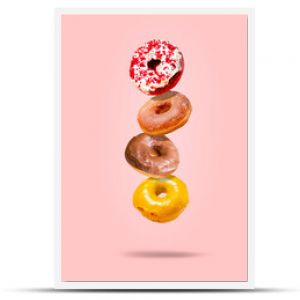 Levitating donuts isolated on a pink background. Modern food concept. Advertising for pastry shops, cafes.