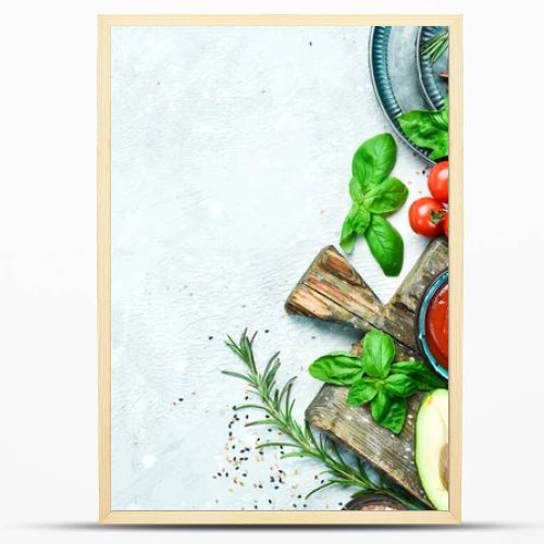 Preparation of pasta. Dry pasta and ingredients: tomatoes, basil, pepper and rosemary, on a gray stone background. Dry pasta. Top view. Free space for text.