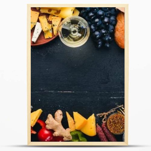 Assorted cheeses, sausages, wines, traditional spices and fresh vegetables on a wooden background. Cheese brie, blue cheese, gorgonzola, fuete, salami. Italian and Spanish Cuisine. Free space.