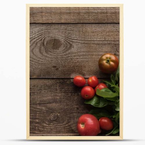 top view of tomatoes with spinach on wooden table 