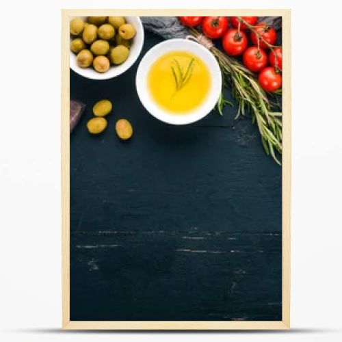 A set of olives, olive oil, bread, cheese and spices. On a black wooden background. Free space for text.