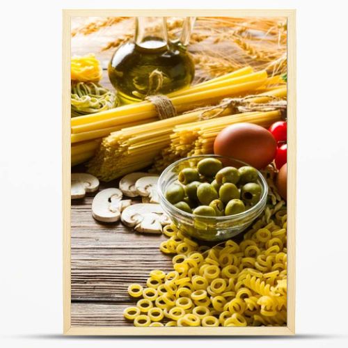 raw pasta and spaghetti, cherry tomatoes and herbs and spices, on a light table, taken from the top angle