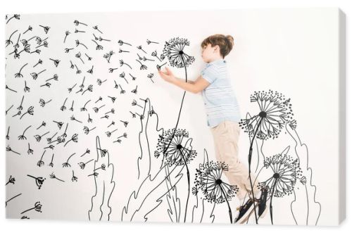 top view of kid blowing dandelion seeds while flying on white 
