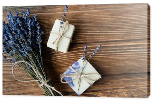 Top view of lavender flowers near handmade soap on wooden surface 