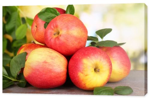 Ripe sweet apples with leaves on nature background