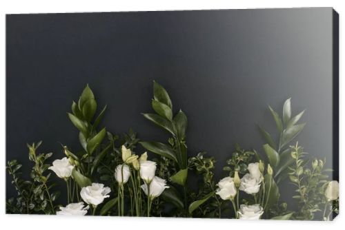 top view of eustoma flowers and branches over black background