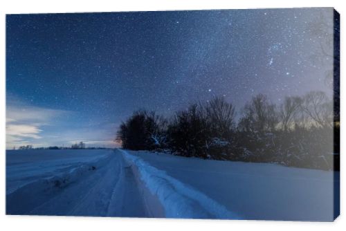 starry dark sky and snowy road in carpathian mountains at night in winter