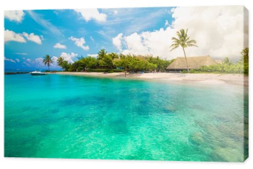 Huahine, French Polynesia. South Pacific. Tropical vacation landscape with lagoon, white sandy beach and palm trees on the island.