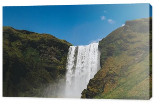 scenic view of waterfall Skogafoss against bright blue sky in Iceland