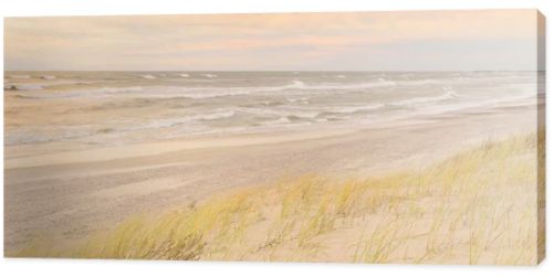 Baltic sea coast (sand dunes) after the storm at sunset. Clear sky, glowing clouds, wind. Autumn landscape. Nature, environmental conservation, ecology, ecotourism, local travel