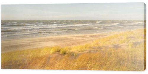 Baltic sea coast (sand dunes) after the storm at sunset. Clear sky, glowing clouds, wind. Autumn landscape. Nature, environmental conservation, ecology, ecotourism, local travel