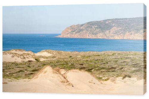 Expansive sand dunes and coastal vegetation with a wide view of the Atlantic Ocean near Guincho Cascais Portugal.