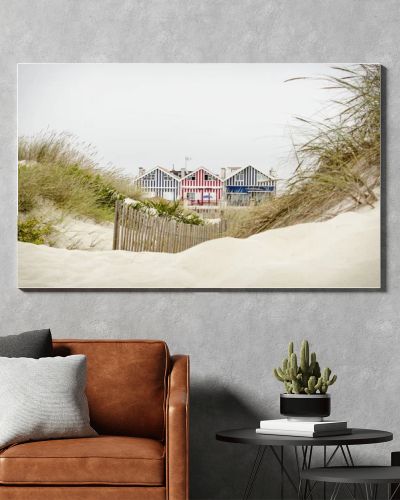 Idyllic and quaint beach houses seen from beach dunes. Beach houses with colorful stripes from Costa Nova, Portugal.