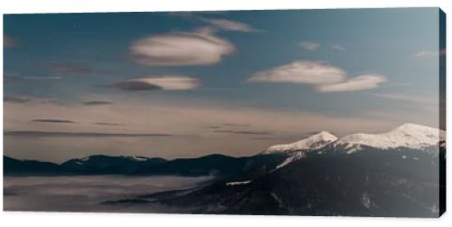 scenic view of snowy mountains with white fluffy clouds in evening, panoramic shot