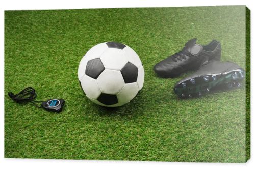 stopwatch with soccer ball and boots on grass