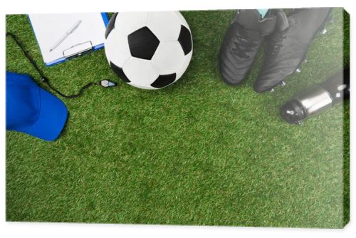 clipboard with soccer ball and boots on grass