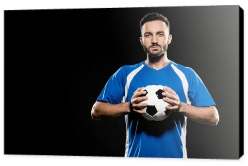 football player holding ball in hands isolated on black