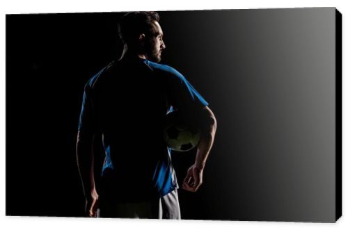 silhouette of muscular sportsman holding ball isolated on black
