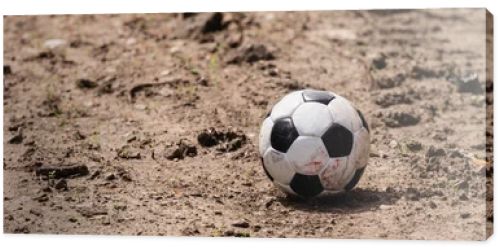 Panoramic shot of football on dirty road on urban street 