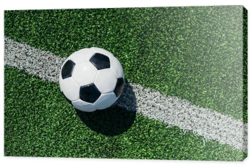 top view of football ball on green grass with white line