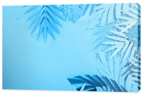 frame of paper leaves on blue minimalistic background with copy space