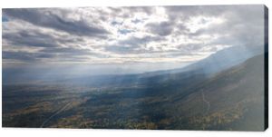 Tatry Słowackie. Niższe tereny zejście z Białej Wody. Widok jak z lotu ptaka. Piękne chmury przez które przebijają się promienie słoneczne. Fotografię dopełniają jesienne kolory drzew. 