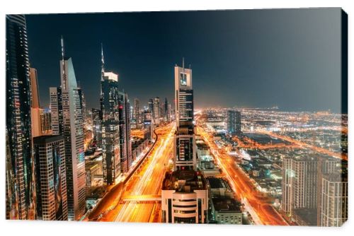 Night view of the spectacular landscape of Dubai with high-rises and skyscrapers at the Sheikh Zayed highway. Global travel destinations and real estate concept