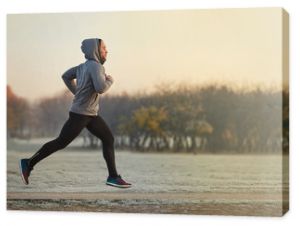 Młody wysportowany mężczyzna biegający w parku podczas zimnego jesiennego poranka