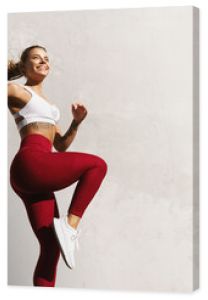 Sprawna kobieta ćwicząca na świeżym powietrzu Zdrowa młoda lekkoatletka robi trening fitness Sportsmenka podnosząca nogę wykonuje trening funkcjonalny