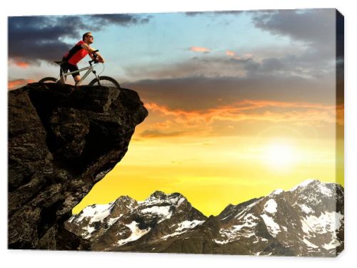 Cyclist on bike at sunset in Pennine Alps