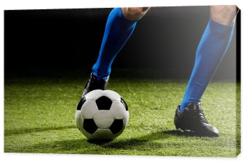 cropped view of sportsman playing with ball on green grass isolated on black