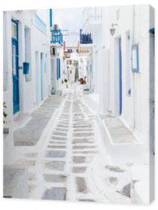 Mykonos Grecja Tradycyjna bielona ulica miasta Mykonos z niebieskimi oknami i drzwiami w słoneczny letni poranek Pusta uliczka