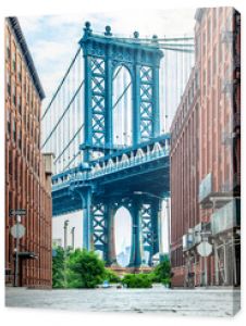 Most Manhattan między Manhattanem a Brooklynem nad East River widziany z wąskiej uliczki otoczonej dwoma ceglanymi budynkami na su
