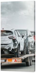 Awaryjna pomoc drogowa na autostradzie, widok z boku lawety z uszkodzonymi pojazdami po wypadku drogowym
