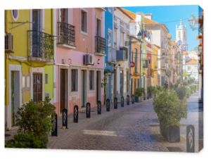 Setubal, Portugal. 16 August 2023. Colorful old houses in a European street, narrow with its ancient buildings, European city. A cityscape of Setúbal with a white church in the distance.